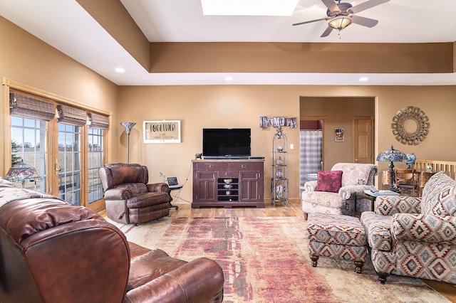 living room featuring a ceiling fan, recessed lighting, wood finished floors, and a skylight