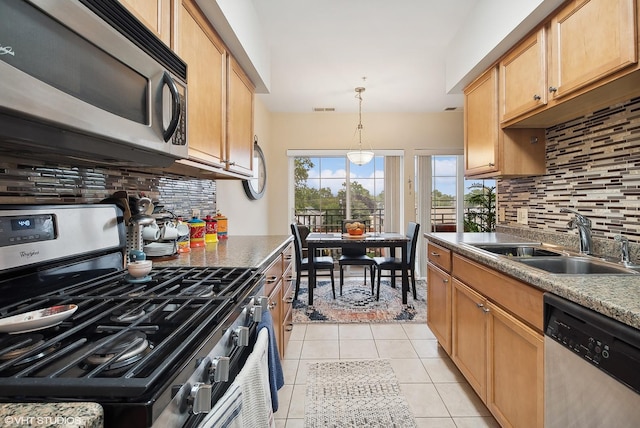 kitchen featuring stainless steel appliances, visible vents, hanging light fixtures, light tile patterned flooring, and a sink