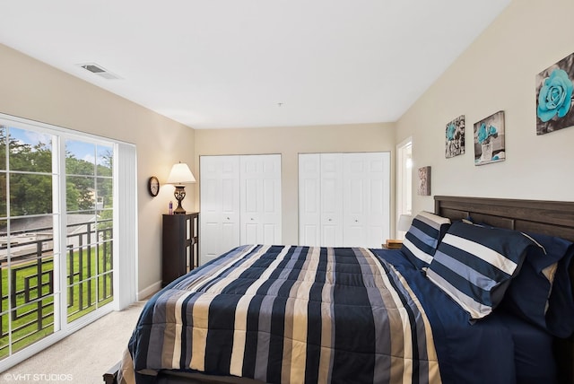 bedroom featuring carpet floors, baseboards, visible vents, and two closets