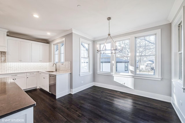 kitchen featuring dark wood-style floors, tasteful backsplash, crown molding, and a sink