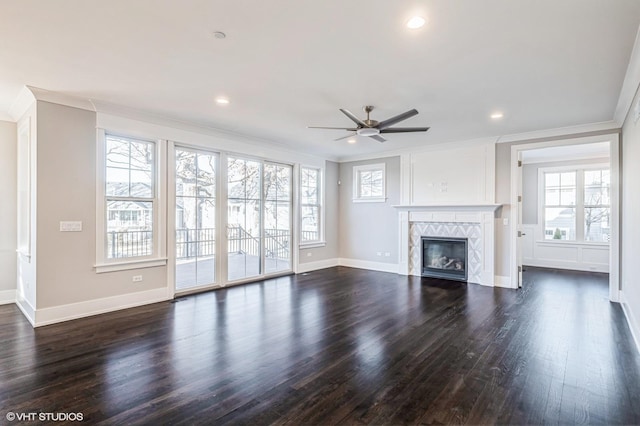 unfurnished living room with ornamental molding, dark wood-type flooring, a tile fireplace, and baseboards