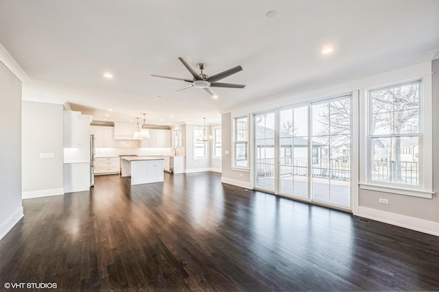 unfurnished living room with a healthy amount of sunlight, baseboards, and dark wood-style flooring