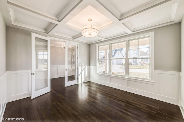 spare room featuring plenty of natural light, dark wood finished floors, beamed ceiling, and french doors