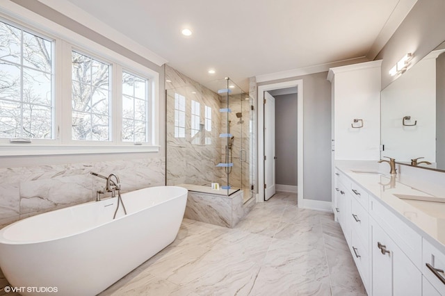 bathroom featuring marble finish floor, a marble finish shower, double vanity, a sink, and a freestanding tub