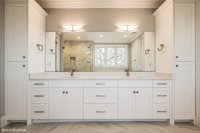 bathroom with double vanity, marble finish floor, a marble finish shower, and a sink