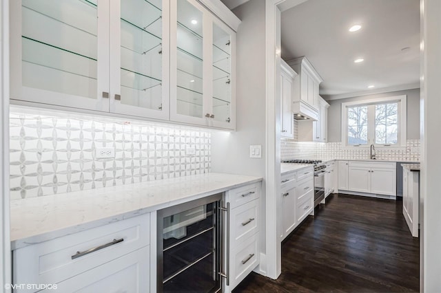 kitchen featuring wine cooler, custom exhaust hood, high end stainless steel range oven, glass insert cabinets, and light stone countertops