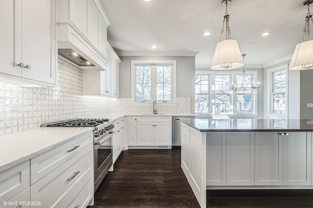 kitchen featuring plenty of natural light, crown molding, appliances with stainless steel finishes, and a sink