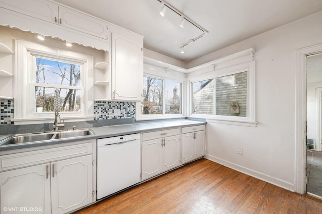 kitchen featuring open shelves, white dishwasher, a sink, and a healthy amount of sunlight