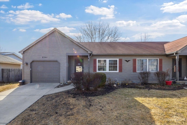 ranch-style home featuring a front yard, concrete driveway, fence, and an attached garage