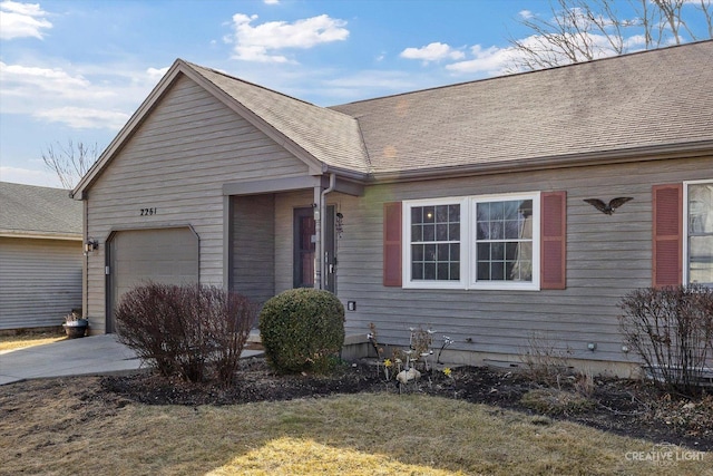 view of front of home with an attached garage, driveway, and a shingled roof