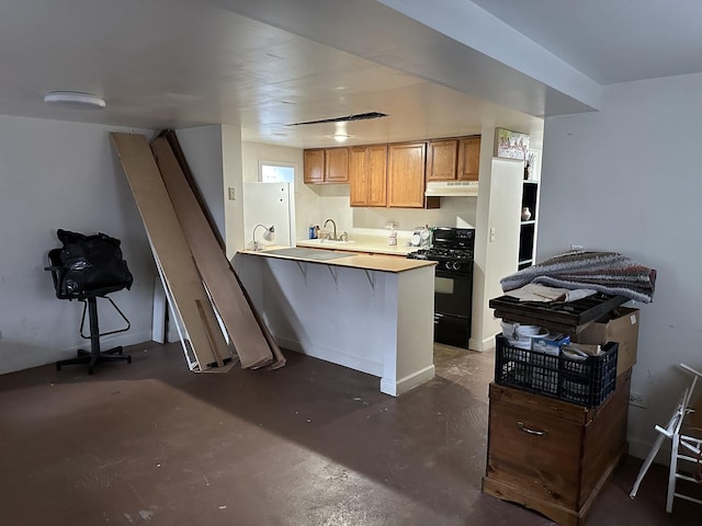 kitchen with a breakfast bar, a peninsula, black range with gas stovetop, concrete flooring, and under cabinet range hood