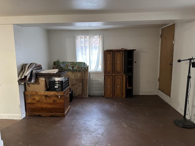 misc room with baseboards and concrete flooring