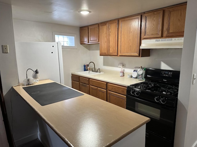 kitchen featuring black gas stove, under cabinet range hood, brown cabinets, and a sink