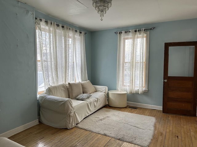 sitting room with baseboards and hardwood / wood-style floors