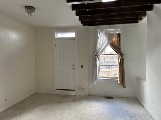 carpeted foyer entrance with a wealth of natural light, visible vents, and baseboards