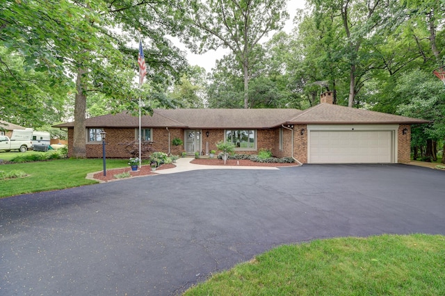 single story home featuring aphalt driveway, brick siding, a chimney, a garage, and a front lawn