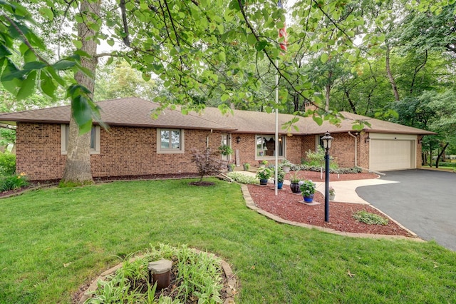 single story home featuring a garage, driveway, a shingled roof, a front lawn, and brick siding