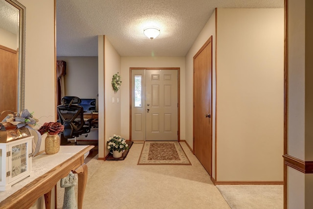 foyer with baseboards and a textured ceiling