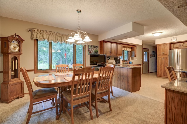 dining room with light carpet, a notable chandelier, baseboards, and a textured ceiling