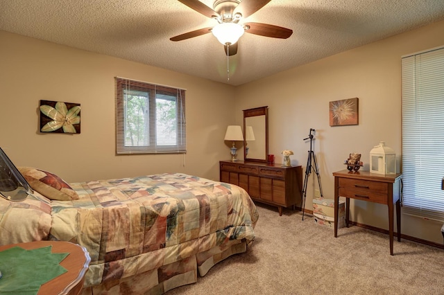 bedroom with a ceiling fan, baseboards, a textured ceiling, and light colored carpet