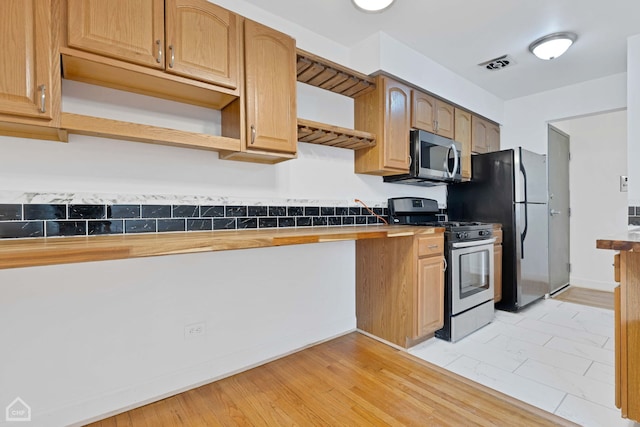 kitchen featuring stainless steel appliances, visible vents, tile counters, and open shelves