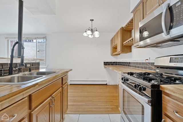 kitchen with stainless steel appliances, a baseboard radiator, hanging light fixtures, a sink, and wood counters