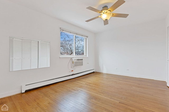 spare room featuring light wood finished floors, a wall mounted AC, a baseboard radiator, and baseboards