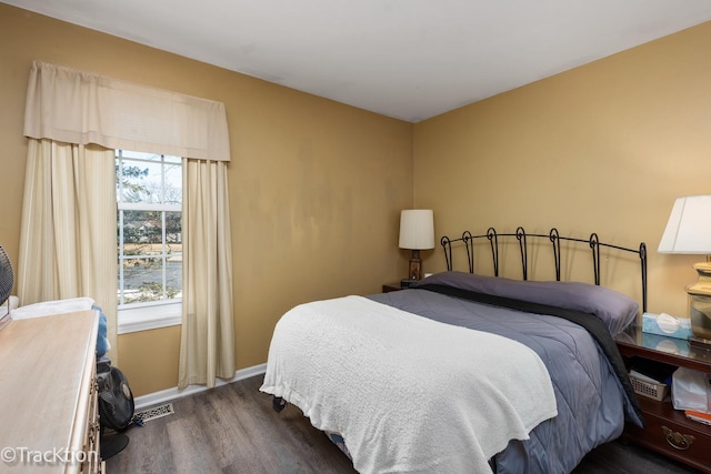 bedroom featuring wood finished floors, visible vents, and baseboards