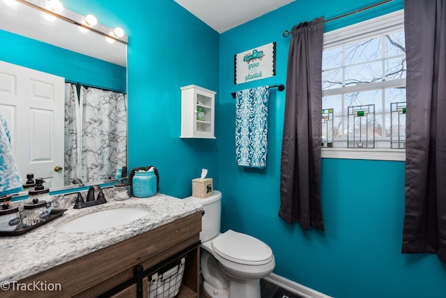 full bathroom featuring a shower with curtain, baseboards, vanity, and toilet