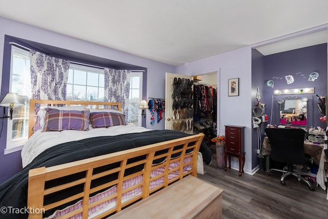 bedroom featuring a closet, wood finished floors, and a walk in closet