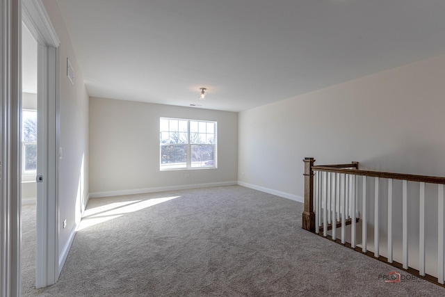 carpeted empty room featuring baseboards