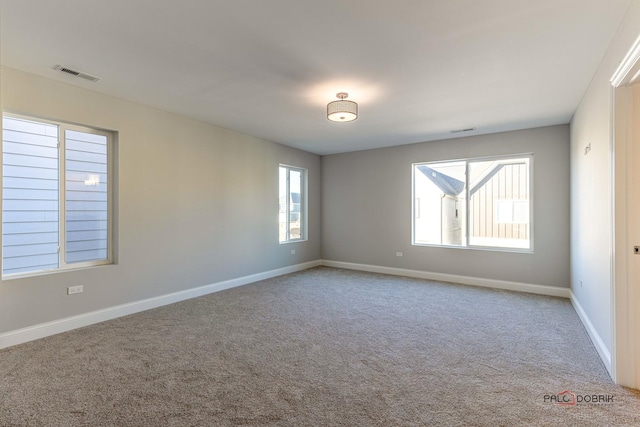 carpeted empty room with baseboards and visible vents