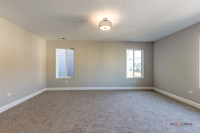 carpeted empty room with baseboards