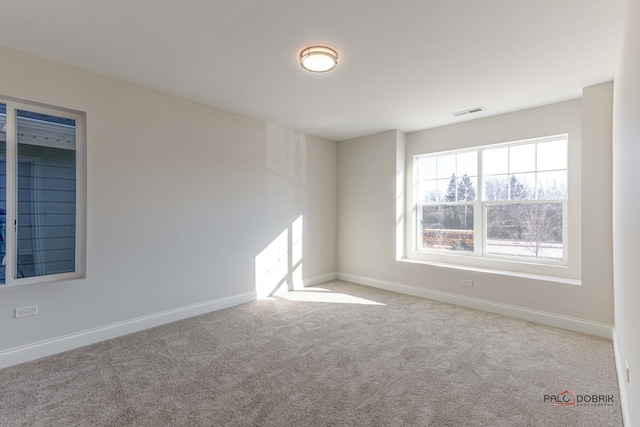 unfurnished room featuring visible vents, baseboards, and carpet flooring