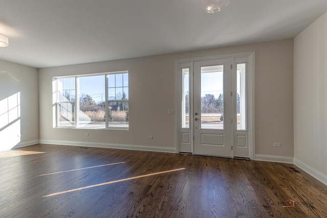 entrance foyer with dark wood-style flooring and baseboards