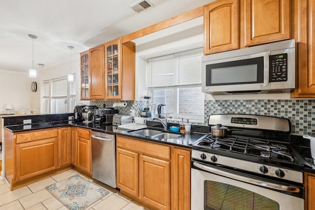 kitchen featuring a peninsula, plenty of natural light, appliances with stainless steel finishes, and a sink