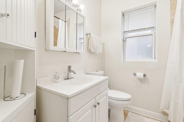 full bath featuring curtained shower, baseboards, vanity, and toilet