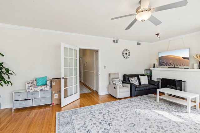 living room with ornamental molding, french doors, visible vents, and wood finished floors