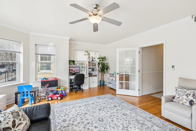 living room featuring french doors, ornamental molding, a ceiling fan, wood finished floors, and baseboards