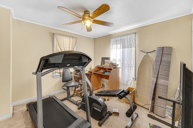 exercise room with ornamental molding, light colored carpet, baseboards, and a ceiling fan