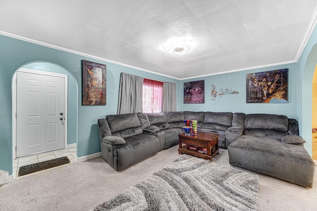 carpeted living room with baseboards, ornamental molding, and arched walkways