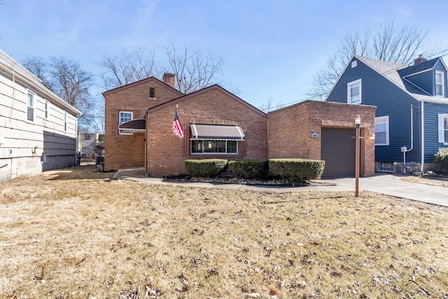 view of front facade with driveway, a garage, a chimney, a front lawn, and brick siding