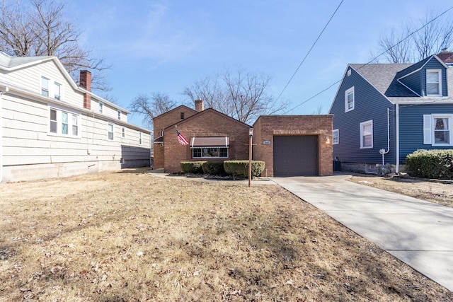 view of front of house with an outbuilding, concrete driveway, and brick siding