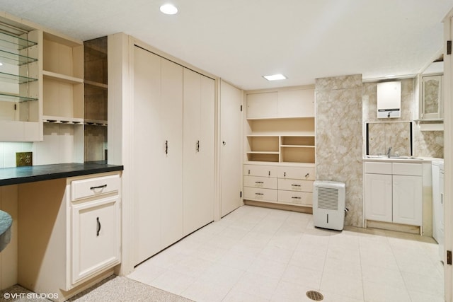 kitchen featuring dark countertops, a sink, recessed lighting, and open shelves