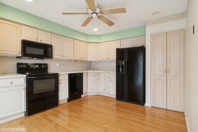 kitchen with ceiling fan, a sink, light countertops, light wood-type flooring, and black appliances