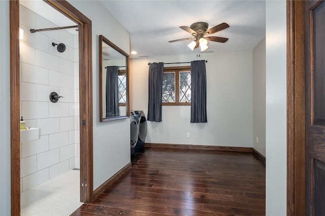 empty room with a ceiling fan, baseboards, dark wood-style flooring, and washer and dryer