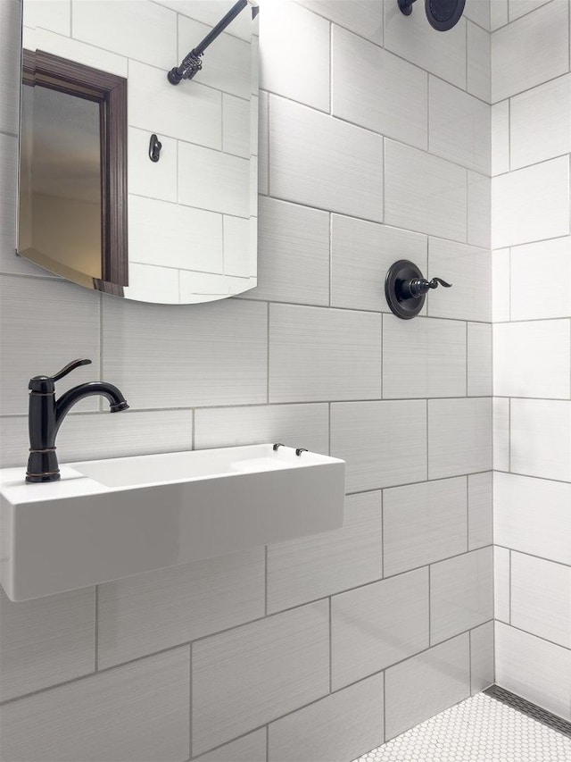 bathroom with a tile shower and a sink