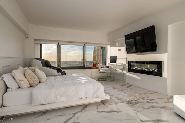 bedroom with a glass covered fireplace and marble finish floor