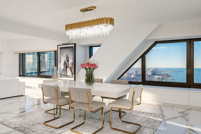 dining area featuring a chandelier, marble finish floor, and a water view