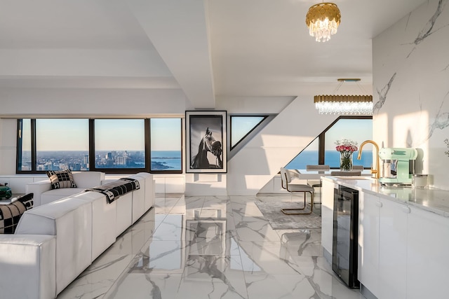 living room featuring wine cooler, marble finish floor, and a chandelier